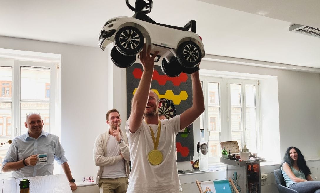 man holding a children car into the air with a medal around his neck