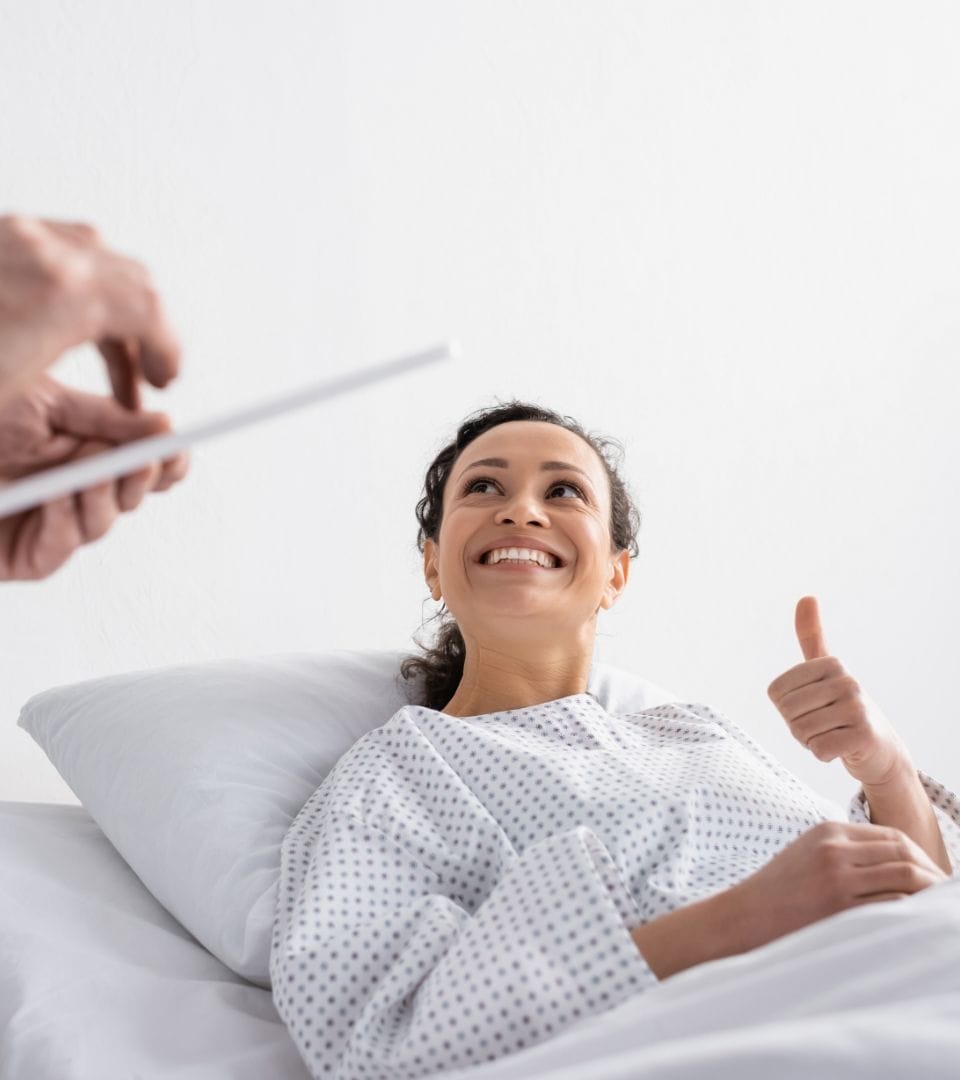 doctor asking patient in hospital bed how she feels (she feels good)