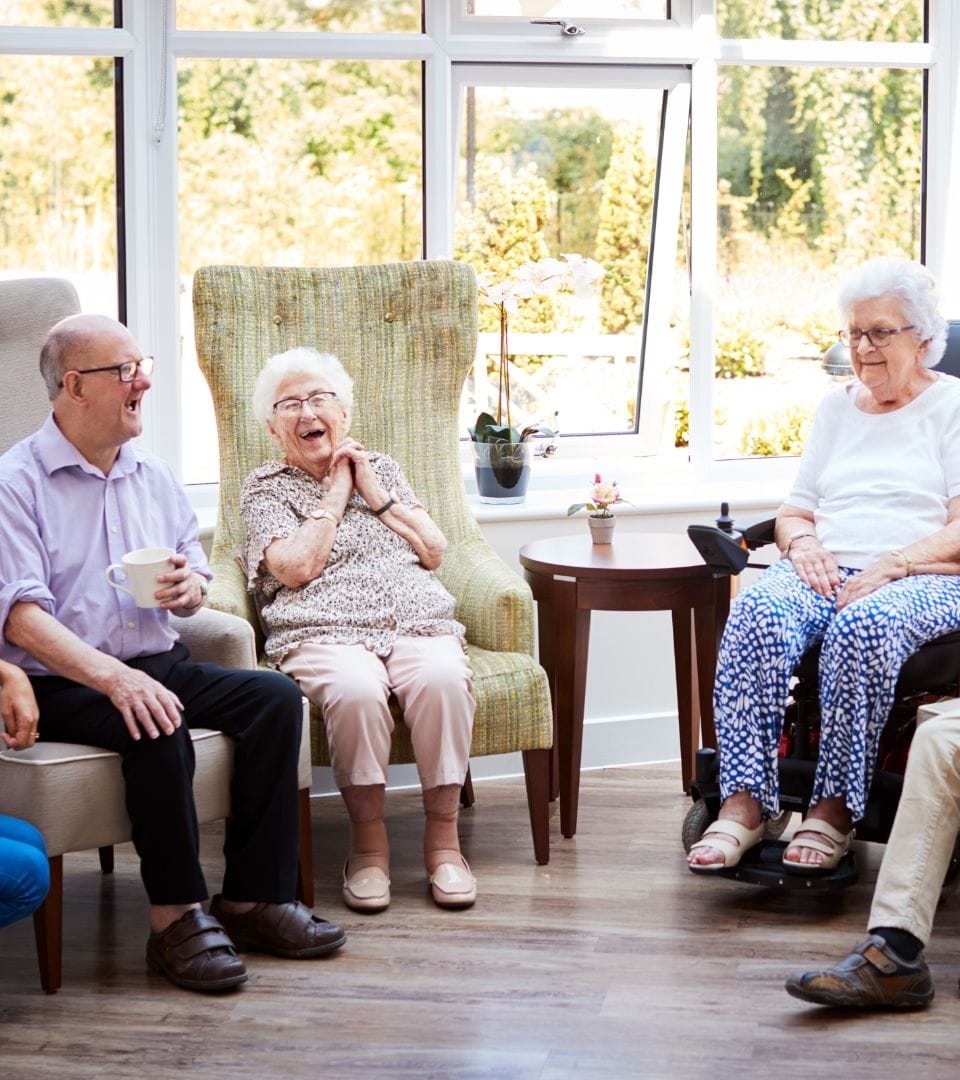 multiple old people sitting togheter talking and having fun