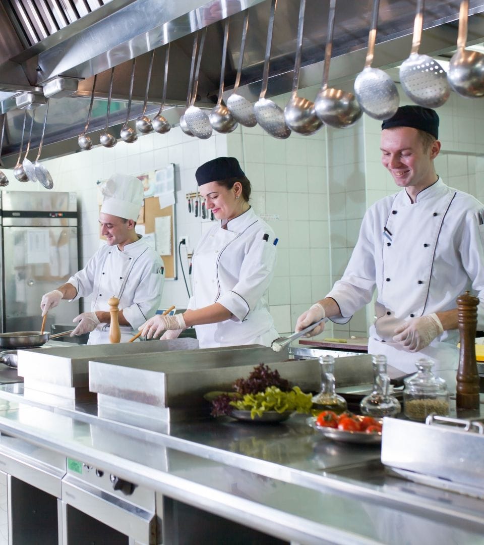 3 people cooking food in a modern kitchen