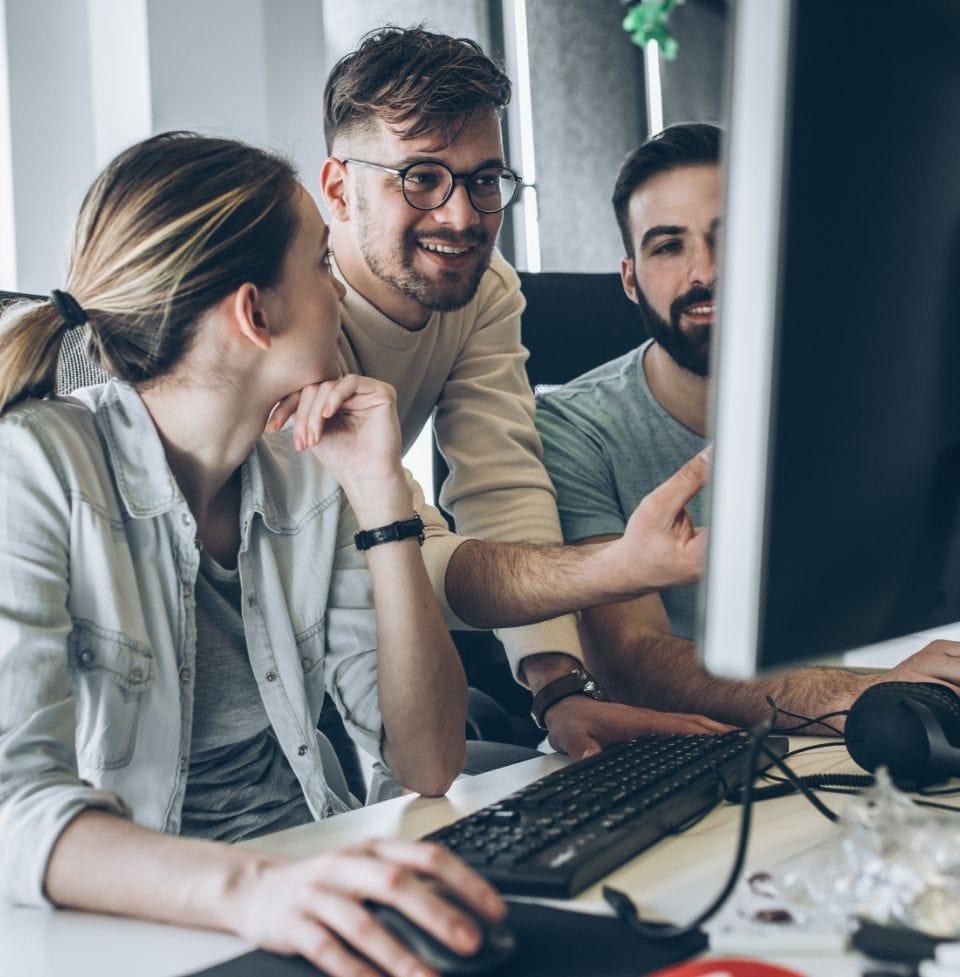 1 woman and 2 man sitting infront of a pc